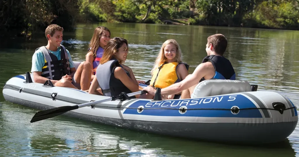 Grupo de cinco jovens navegando em bote inflável Excursion 5 em rio calmo