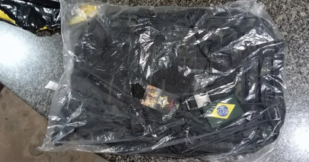 Mochila tática preta embalada no plástico original com bandeira do Brasil e etiqueta de fábrica